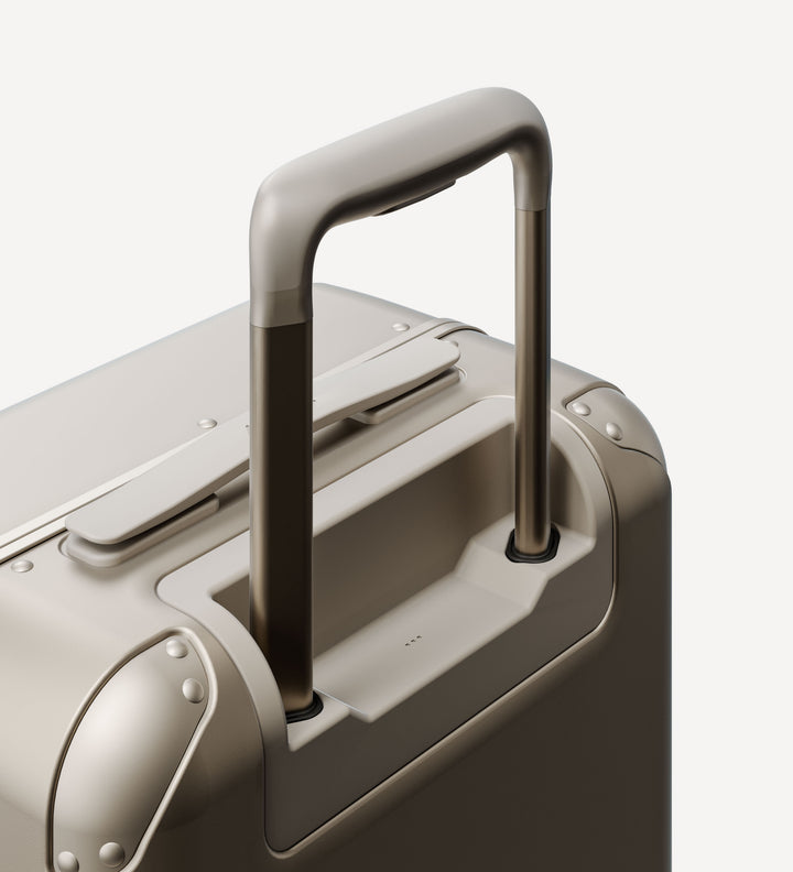 Close-up of the handle and back side of a hybrid carry-on suitcase in champagne, showcasing the smooth telescopic handle system.