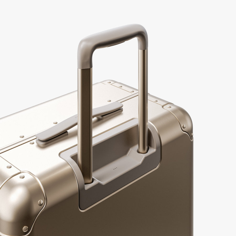 Champagne Gold | Extended luggage handle view of Aluminum Check-In Medium in Champagne Gold