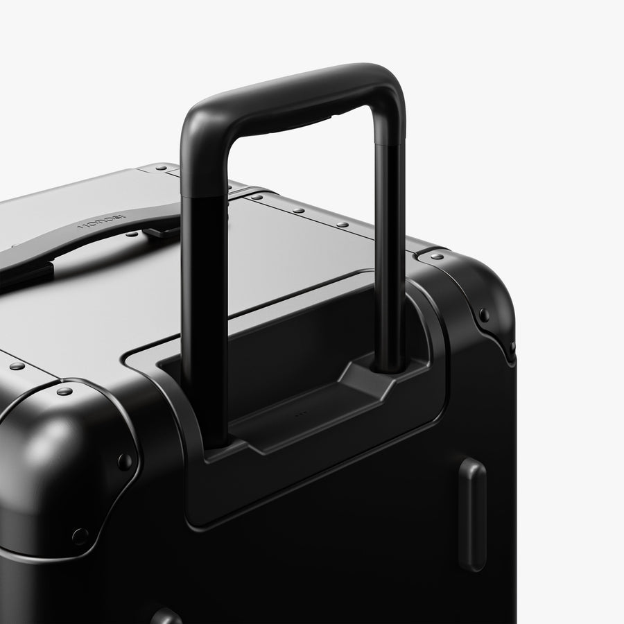 Caviar Black | Extended luggage handle view of Aluminum Trunk in Caviar Black