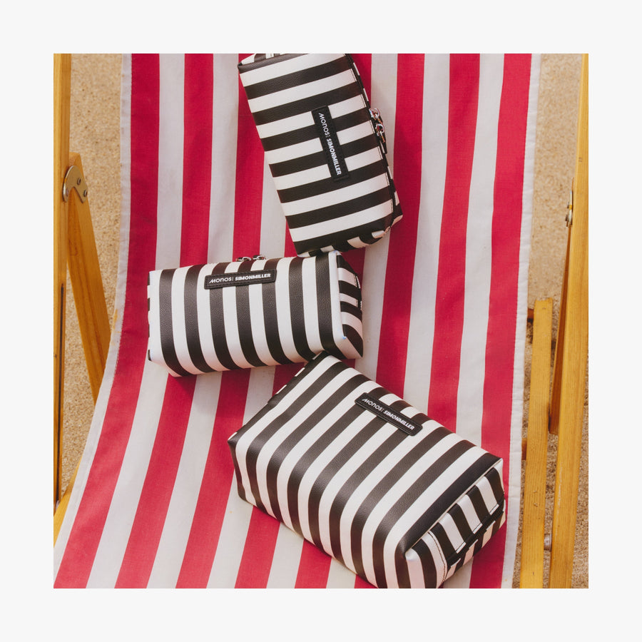 Large / Poplin Stripe Black | Three Metro Toiletry Cases in Poplin Stripe Black displayed on a red and white striped beach chair