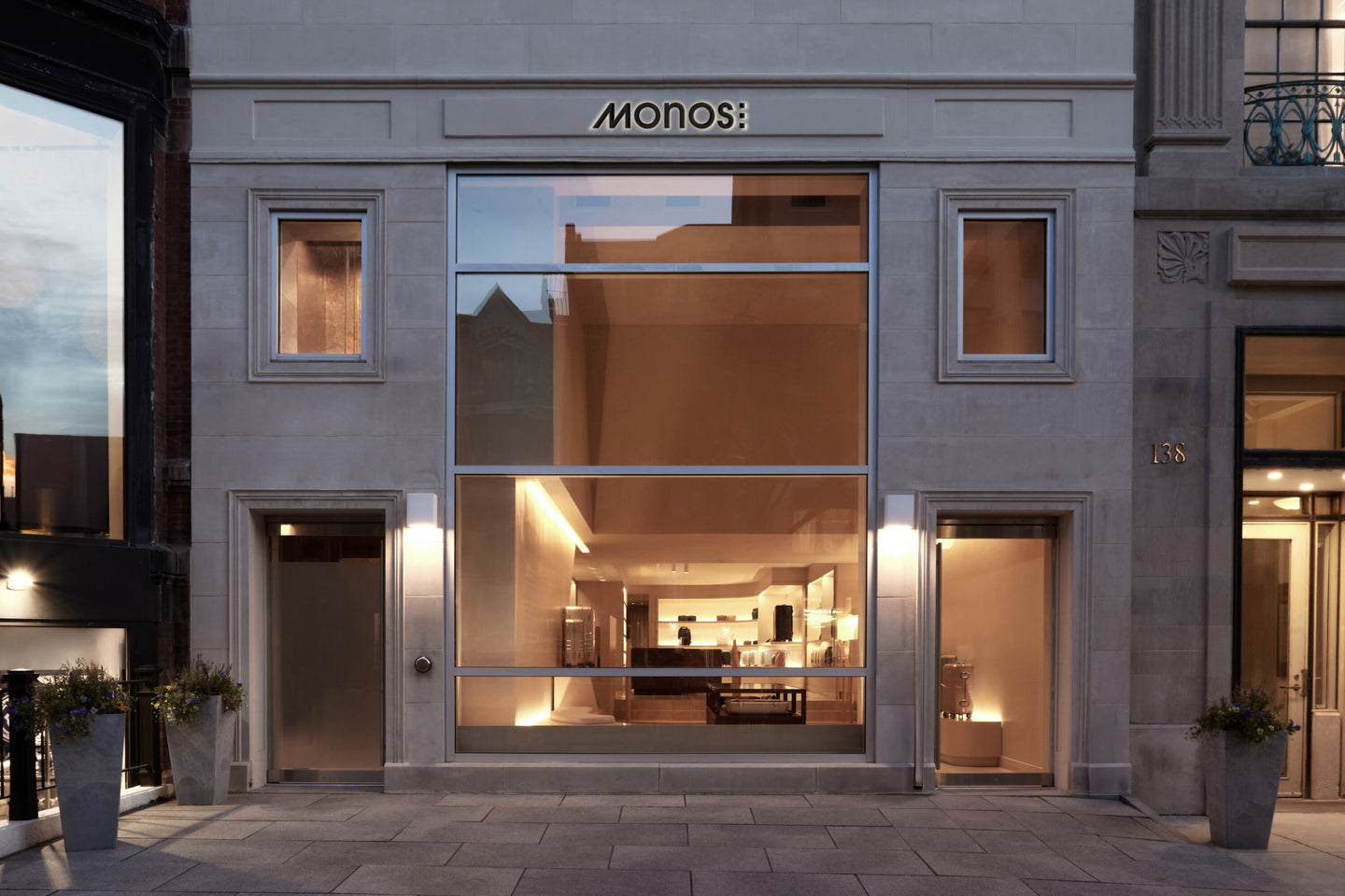 Monos Boston store exterior on Newbury Street, with large glass windows and minimal stone façade.
