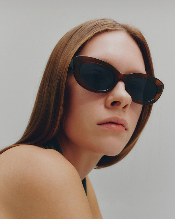 Woman wearing sunglasses with a neutral background
