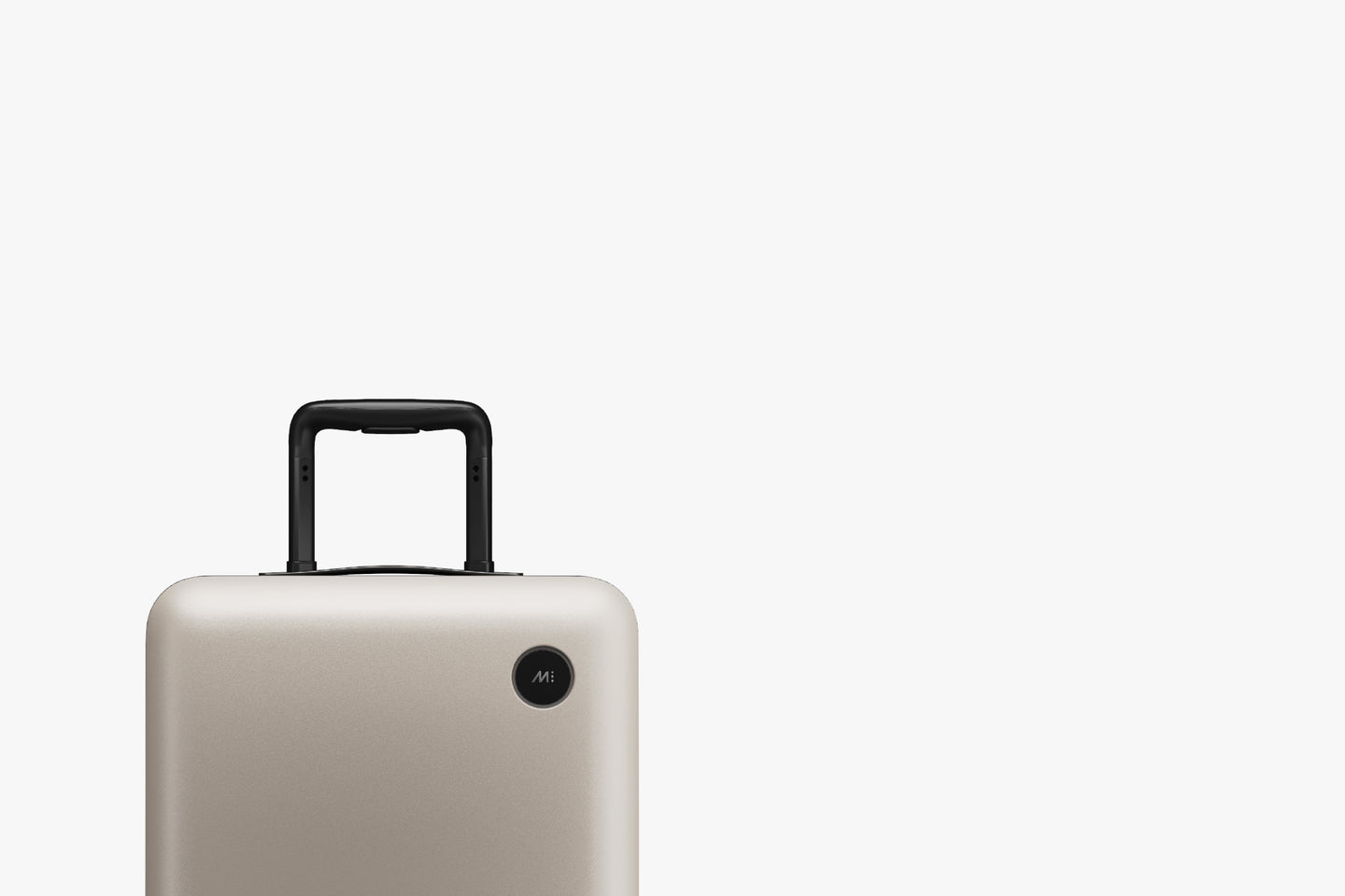 A close-up cropped photo of a Carry-On in Desert Taupe showcasing its black handle and a Monos logo on the top corner.