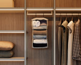 The Packable Hanging Closet suspended in a warm-toned wardrobe, perfectly organized beside a row of minimalist garments.