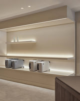 Monos Classic Collection luggage displayed on illuminated shelving inside the Boston store.