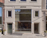 Monos Boston store exterior on Newbury Street with large glass windows and minimal stone façade in daylight.