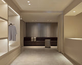 Monos Boston store interior with Hybrid Collection luggage displayed in a neutral-toned space with soft drapery.